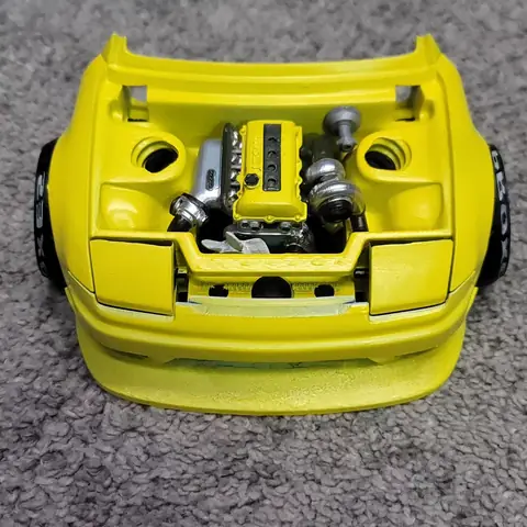 Modelo amarillo de Nissan Silvia S13 con el capó abierto y motor SR20DET impreso en 3D