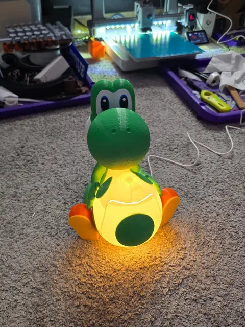 Lámpara de Yoshi en el taller junto a una impresora con luces LED