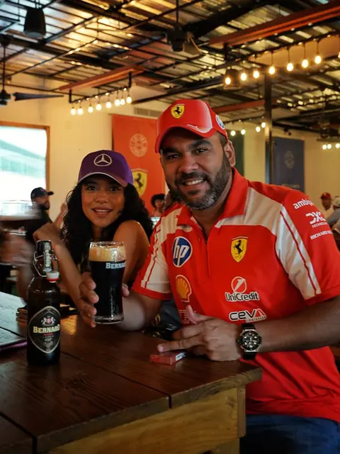 Asistentes con ropa de Ferrari en una mesa del evento