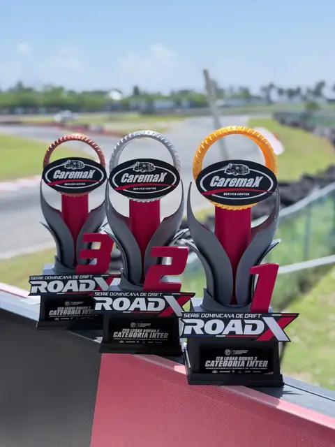 Trofeos del podio ROADX vistos desde otro ángulo, con la pista de fondo
